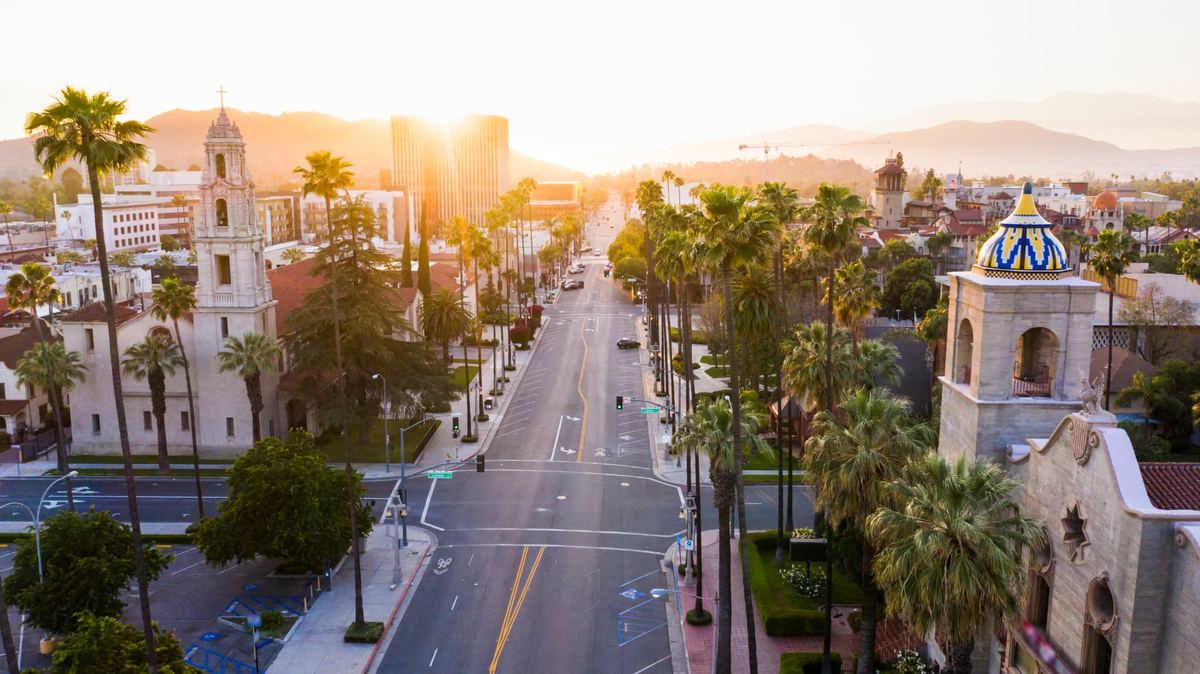 Downtown Riverside, California at sunset, with a palm-lined street and historic architecture
